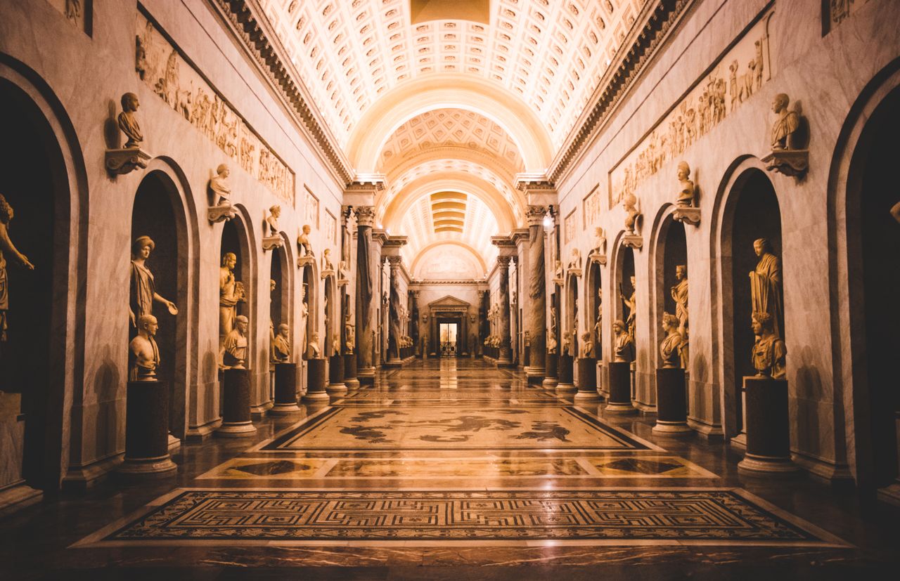 A stunning view of a hallway adorned with classical sculptures in the Vatican Museums.